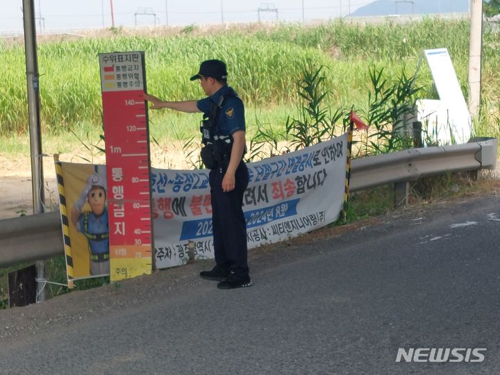 [광주=뉴시스] 집중호우를 대비해 광주 광산구 송정2교를 점검하는 광산경찰서 경찰관. (사진=광산경찰서 제공) 2024.07.05. photo@newsis.com