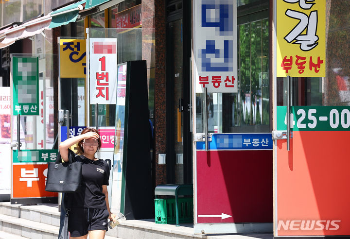 [서울=뉴시스] 김근수 기자 = 서울 시내의 부동산 사무실 앞으로 시민이 지나가고 있다. 2024.07.10. ks@newsis.com