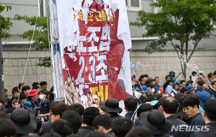 [광주=뉴시스] 김혜인 기자 = 전국금속노동조합 광주·전남지부가 10일 오후 광주 광산구 오선동 진곡산단 한 자동차 부품 제조 공장 앞에서 '노조법 개정·타임오프 폐기' 촉구 총파업대회를 열고 노조법 개정을 촉구하며 물풍선을 던지는 퍼포먼스를 하고 있다. 2024.07.10. hyein0342@newsis.com