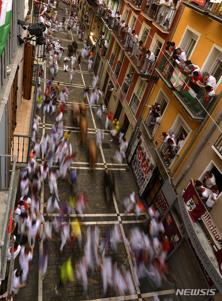 [팜플로나=AP/뉴시스] 11일(현지시각) 스페인 팜플로나에서 열리고 있는 연례 산 페르민 축제 중 황소와 달리기(엔시에로) 참가자들이 골목길을 달리고 있다. 2023.07.11.