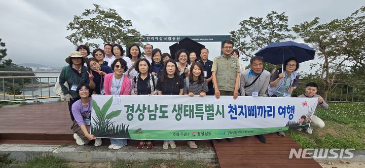 [남해=뉴시스]경남환경재단 '천지삐까리 여행'에 참여한 여행객들이 지난 9일 한려해상국립공원에서 상괭이와 흰발농게 해설을 들은 후 기념촬영하고 있다.(사진=경남환경재단 제공)2024.07.12. photo@newsis.com