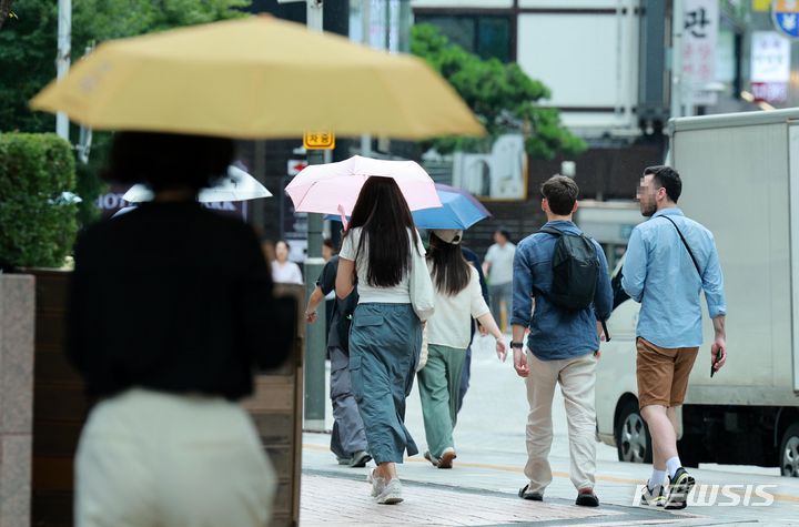 [서울=뉴시스] 고범준 기자 = 전국적으로 장맛비가 내리는 16일 오후 서울 중구 명동거리 인근에서 시민들이 우산을 쓰고 지나가고 있다. 2024.07.16. bjko@newsis.com