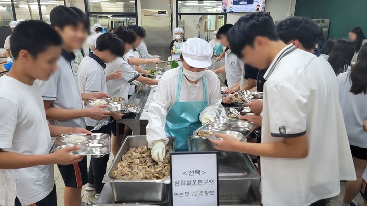 [화성=뉴시스] 박종대 기자 = 17일 오후 경기 화성시 동탄중학교 급식실에서 학생들이 점심식사를 먹기 위해 식판에 음식을 담고 있다. 동탄중은 지난해 1학기부터 임태희 교육감 취임 이후 도입된 자율선택급식을 운영 중이다. 2024.07.17. pjd@newsis.com *재판매 및 DB 금지