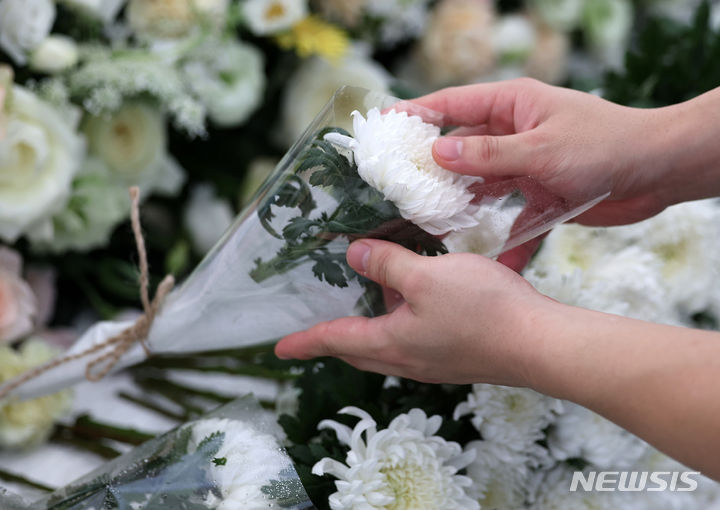 [서울=뉴시스] 서이초 교사 사망 1주기인 지난 7월18일 오후 서울 서초구 서이초등학교에 마련된 추모장소에서 추모객이 헌화를 하고 있다. (사진=뉴시스DB). 2024.10.12. photo@newsis.com