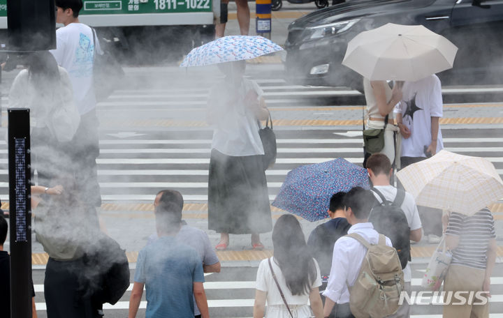 [부산=뉴시스] 하경민 기자 = 부산지역에 폭염주의보가 발효 중인 22일 동구 부산역 앞에서 시민들이 쿨링포그가 작동하는 횡단보도를 건너고 있다. 2024.07.22. yulnetphoto@newsis.com