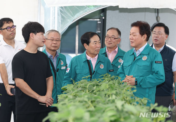 [창녕=뉴시스]23일 경남 창녕 비닐하우스 밀집 영농작업 현장을 방문한 박완수(오른쪽서 두 번째) 도지사가 젊은 농업인과 얘기하고 있다.(사진=경남도 제공) 2024.07.23. photo@newsis.com