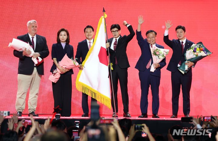 [고양=뉴시스] 조성봉 기자 = 한동훈 국민의힘 대표가 23일 경기 고양 킨텍스에서 열린 제4차 국민의힘 전당대회에서 당 깃발을 들고 최고위원들과 기념촬영을 하고 있다. 2024.07.23. suncho21@newsis.com