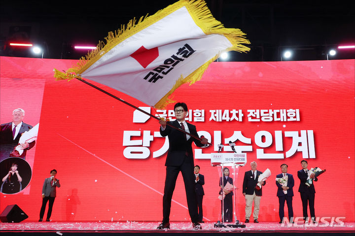 [고양=뉴시스] 고승민 기자 = 한동훈 국민의힘 신임 당대표가 23일 오후 경기도 고양시 킨텍스에서 열린 국민의힘 제4차 전당대회에서 국민의힘 당기를 흔들고 있다. (공동취재) 2024.07.23. photo@newsis.com