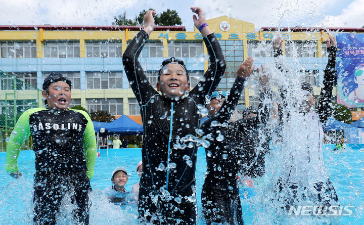 [서울=뉴시스] 추상철 기자 = 26일 오전 방학중인 서울 성북구 성북초등학교 운동장에 마련된 워터파크에서 열린 '2024 제8회 성북문화바캉스'에서 어린이들이 물놀이를 하며 무더위를 식히고 있다. 2024.07.26. scchoo@newsis.com