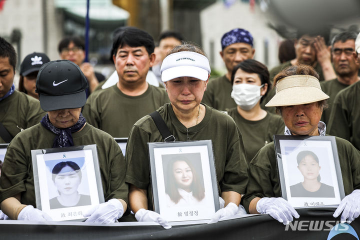 [서울=뉴시스] 정병혁 기자 = 27일 서울 용산구 대통령실 앞에서 열린 아리셀 중대재해 참사 희생자 가족 영정 행진에 앞서 희생자 유가족과 참석자들이 영정을 들고 있다. 2024.07.27. jhope@newsis.com