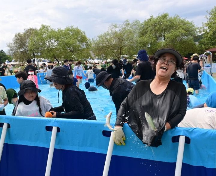 [봉화=뉴시스] 봉화은어축제 방문객들이 '은어 맨손잡이'에 참가해 은어를 잡고 있다. (사진=봉화군 제공) 2024.07.28. photo@newsis.com *재판매 및 DB 금지