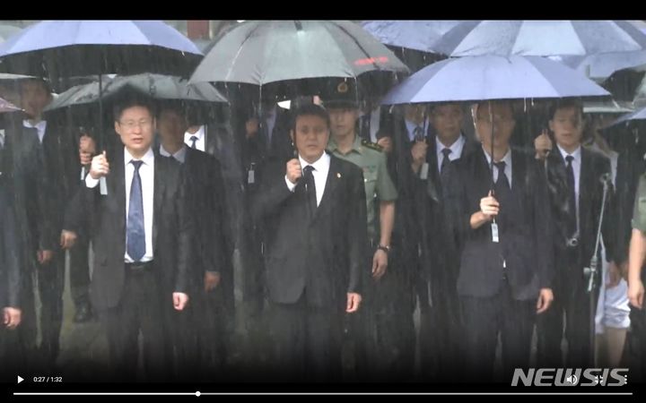 [베이징=뉴시스] 주(駐)북한 중국대사관은 28일 홈페이지에 '큰 빗속의 애도'라는 제목으로 공개한 1분32초짜리 영상을 통해 북한에 내린 폭우 모습을 공개했다. 사진은 지난 25일 평안남도 회창군에 있는 운산 중국인민지원군 열사릉원을 참배하는 왕야쥔 주북 중국대사 일행의 영상 속 모습. 2024.7.29 photo@newsis.com