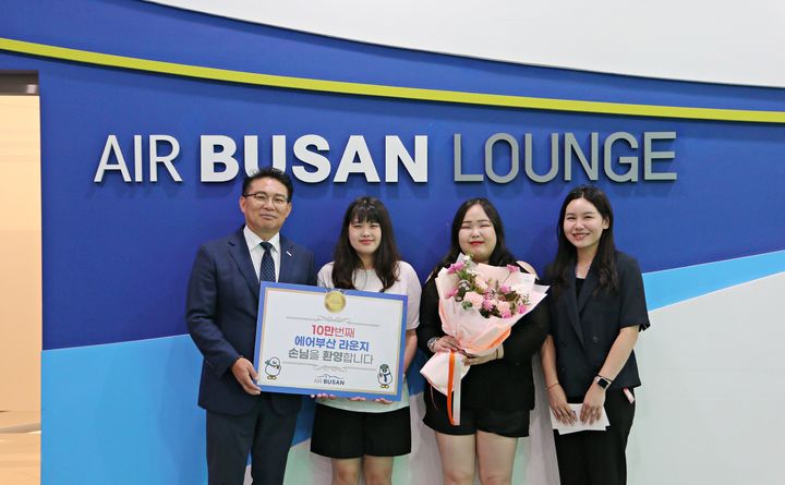 [부산=뉴시스] 1일 김해공항 에어부산 라운지에서 에어부산 마호진(왼쪽에서 첫번째) 영업본부장과 관계자가 10만 번째 입장객에게 국제선 왕복항공권과 기념품을 전달한 후 기념 촬영을 하고 있다. (사진=에어부산 제공) 2024.08.01. photo @newsis.com *재판매 및 DB 금지