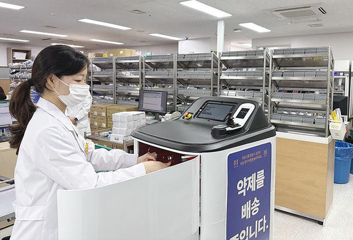 약제 이송 로봇에 약제를 싣고 있는 모습 *재판매 및 DB 금지