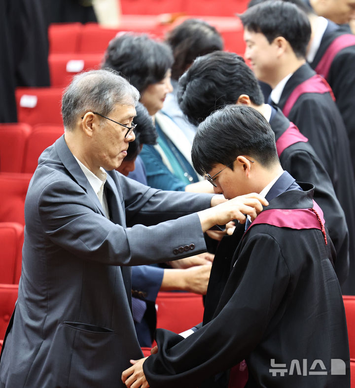 [과천=뉴시스] 김금보 기자 = 1일 경기 과천시 정부 과천종합청사 법무부에서 열린 신임 검사 임관식에서 가족들이 신임 검사들에게 법복을 입혀주고 있다. 2024.08.01. kgb@newsis.com