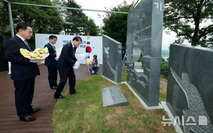 [파주=뉴시스] 고범준 기자 = 김영호 통일부 장관이 1일 오전 경기 파주시 탄현면 오두산 전망대 뒤뜰에서 열린 북한이탈주민의 날 기념 조형물 제막식에서 헌화 하고 있다. 왼쪽부터 태영호 민주평화통일자문회의 사무처장, 김 장관, 지성호 전 국회의원. 2024.08.01. bjko@newsis.com