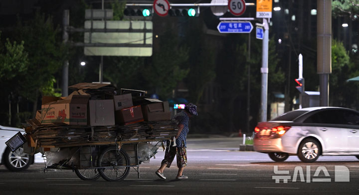 [광주=뉴시스] 이영주 기자 = 광주 지역에 폭염경보가 12일째 이어지고 있는 지난 2일 오후 광주 북구 대인교차로에서 한 어르신이 폐지가 가득 실린 수레를 끌고 있는 모습. 2024.08.02. leeyj2578@newsis.com