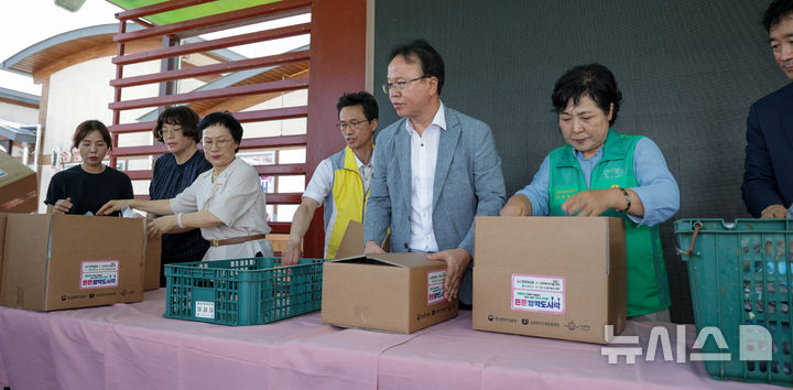 [나주=뉴시스] 한전KDN 임직원과 유관기관 관계자들이 여름방학 기간 경제적으로 어려운 가구 아동들에게 전달할 도시락을 포장하고 있다. (사진=한전KDN 제공) 2024.08.02. photo@newsis.com *재판매 및 DB 금지