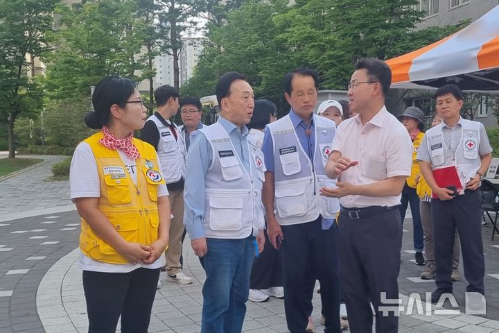 [인천=뉴시스] 전기차 폭발 화재가 발생한 인천 서구 청라동의 아파트 단지에서 위극 한국전력공사 인천본부장(앞줄 맨 오른쪽)이 대한적십자사 인천지사 관계자들과 대화하고 있다. (사진=한전 인천본부 제공)