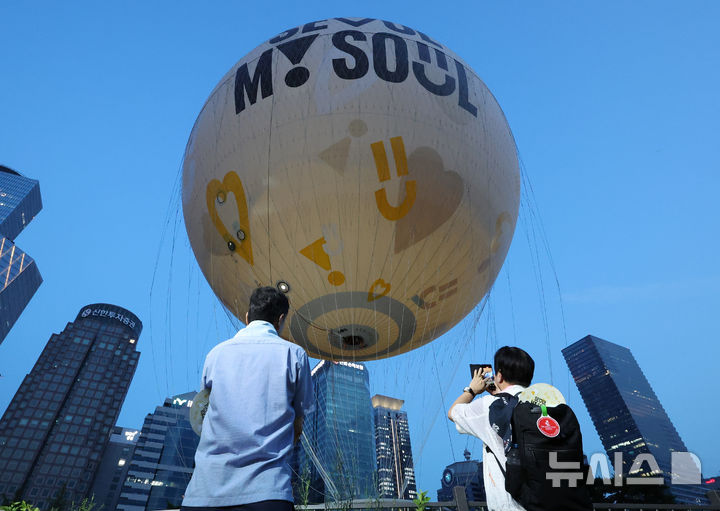 [서울=뉴시스] 김근수 기자 = 10일 서울 영등포구 여의도 근린공원 잔디마당에서 열린 서울달 개장식에서 시민들이 서울달 열기구를 찍고 있다. 2024.08.10. ks@newsis.com