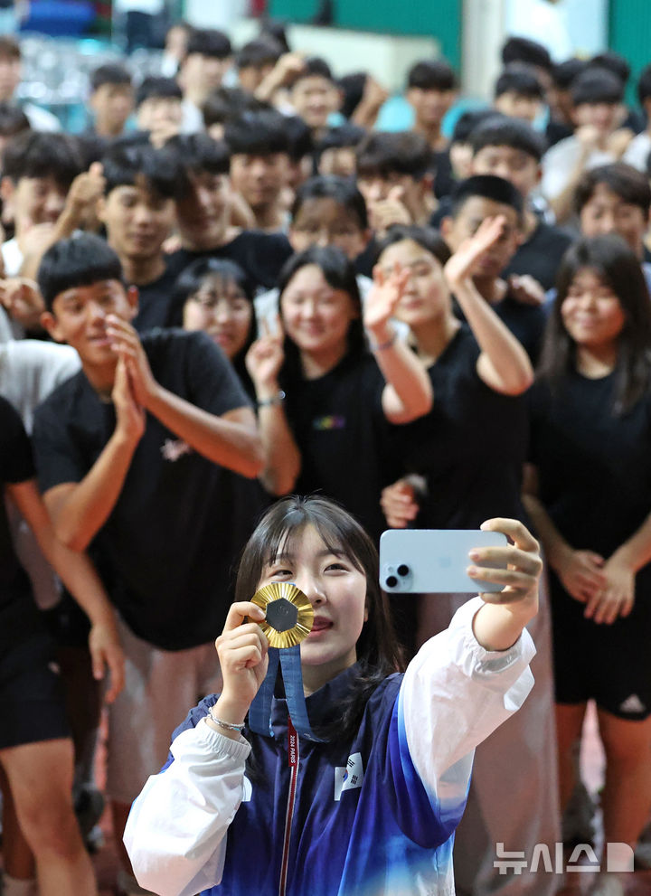 [대구=뉴시스] 이무열 기자 = 2024 파리 올림픽 한국 사격 국가대표 반효진이 지난달 12일 오전 대구 북구 대구체육고등학교 필승관에서 열린 ‘파리올림픽 신기록 수립 및 100번째 금메달 획득 기념 환영식’에서 재학생들과 셀카를 찍고 있다. 2024.09.09. lmy@newsis.com