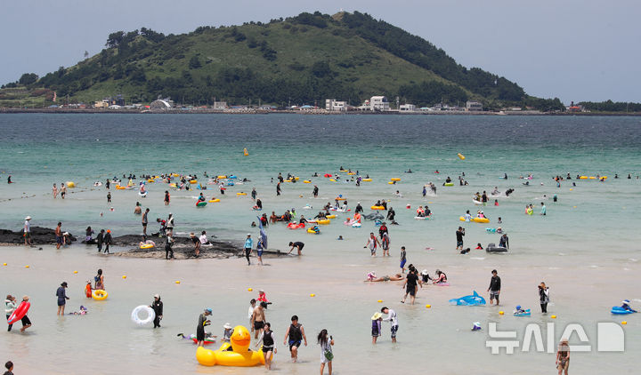 [제주=뉴시스] 우장호 기자 = 전국 대부분 지역에 폭염특보가 발효 중인 13일 오후 제주시 한림읍 협재해수욕장을 찾은 관광객들이 시원한 바닷물에 몸을 담그며 한낮 더위를 식히고 있다. 2024.08.13. woo1223@newsis.com