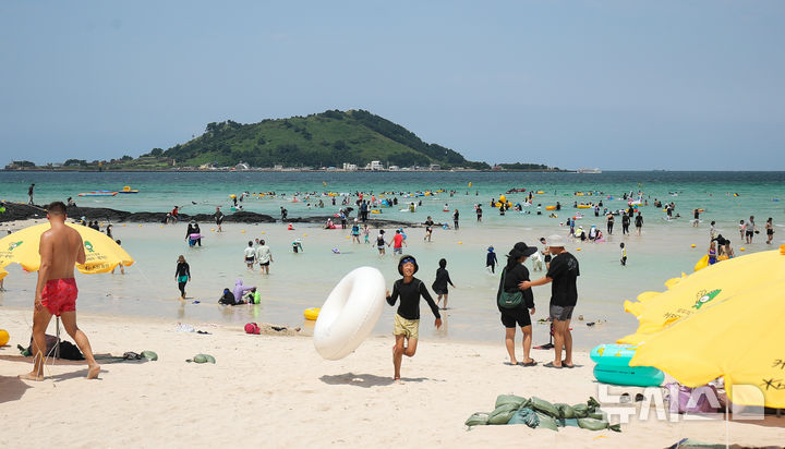 [제주=뉴시스] 우장호 기자 = 전국 대부분 지역에 폭염특보가 발효 중인 13일 오후 제주시 한림읍 협재해수욕장을 찾은 관광객들이 시원한 바닷물에 몸을 담그며 한낮 더위를 식히고 있다. 2024.08.13. woo1223@newsis.com