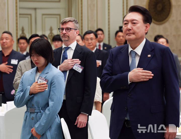 [서울=뉴시스] 최진석 기자 = 윤석열 대통령이 14일 청와대 영빈관에서 열린 독립유공자 후손 초청 오찬에서 독립유공자 후손 등을 비롯한 참석자들과 국기에 경례를 하고 있다. 왼쪽은 독립운동가 허석 의사의 후손인 2024 파리올림픽 유도 개인전 은메달, 혼성 단체전 동메달리스트 허미미. (대통령실통신사진기자단) 2024.08.14. myjs@newsis.com