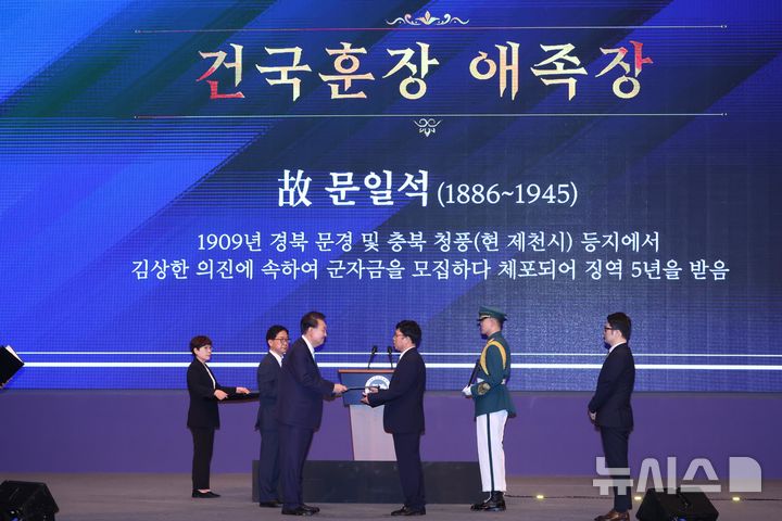 [서울=뉴시스] 조수정 기자 = 윤석열 대통령과 부인 김건희 여사가 15일 서울 종로구 세종문화회관에서 열린 제79주년 광복절 경축식에서 독립유공자 고(故) 문일석 선생 증손자 문혁배 씨에게 건국훈장애족장을 수여하고 있다. 2024.08.15. chocrystal@newsis.com