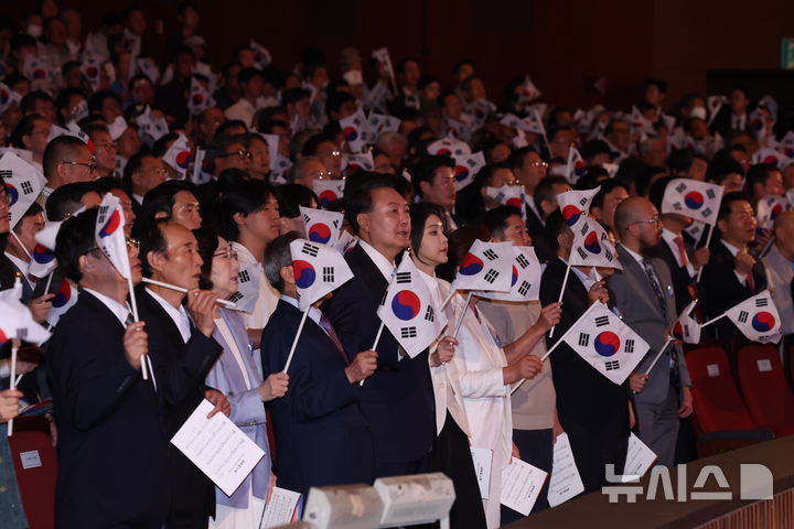 [서울=뉴시스] 조수정 기자 = 윤석열 대통령과 부인 김건희 여사를 비롯한 참석자들이 15일 서울 종로구 세종문화회관에서 열린 제79주년 광복절 경축식에서 태극기를 흔들며 광복절 노래를 제창 하고 있다. 2024.08.15. chocrystal@newsis.com