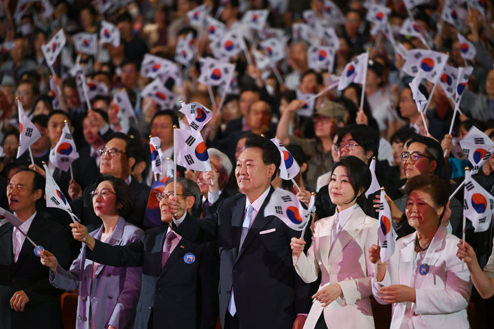 [서울=뉴시스] 조수정 기자 = 윤석열 대통령과 부인 김건희 여사가 15일 서울 종로구 세종문화회관에서 열린 제79주년 광복절 경축식에서 광복절의 노래에 맞춰 태극기를 흔들고 있다. (사진=대통령실 제공) 2024.08.15. photo@newsis.com *재판매 및 DB 금지