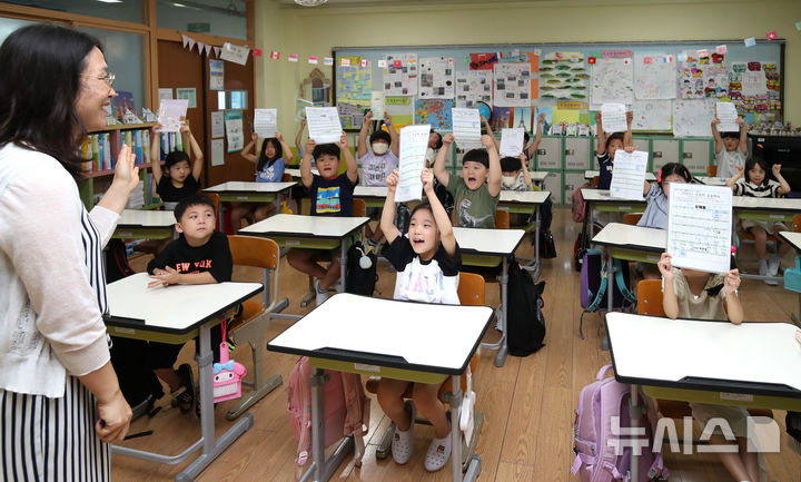 [대구=뉴시스] 이무열 기자 = 여름방학을 마치고 개학한 19일 오전 대구 달서구 대구덕인초등학교 2학년 2반 학생들이 방학숙제를 들어 보이고 있다. 2024.08.19. lmy@newsis.com