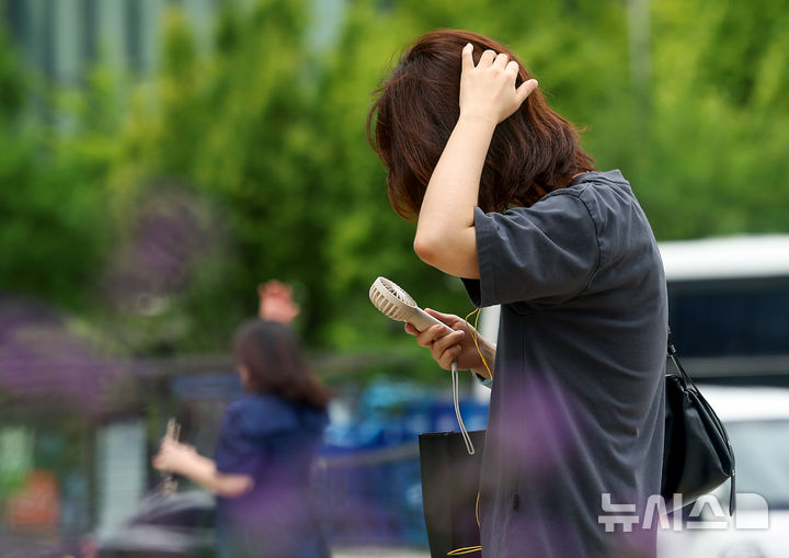 [서울=뉴시스] 김명년 기자 = 절기상 더위가 그친다는 처서인 22일 오후 서울 종로구 광화문사거리에서 한 시민이 휴대용 선풍기를 들고 길을 지나가고 있다. 2024.08.06. kmn@newsis.com