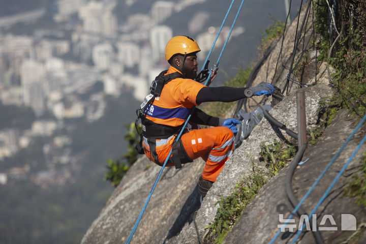 [리우데자네이루=AP/뉴시스]    Montanhistas escalam a montanha para limpar destroços deixados nas encostas da estátua de Jesus no Morro do Corcovado, no Rio de Janeiro, Brasil, no dia 22 (horário local). São escaladores certificados contratados para limpar as famosas montanhas da cidade, coletando não apenas lixo, mas também materiais inflamáveis ​​que representam risco de incêndio florestal. 2024.08.23.