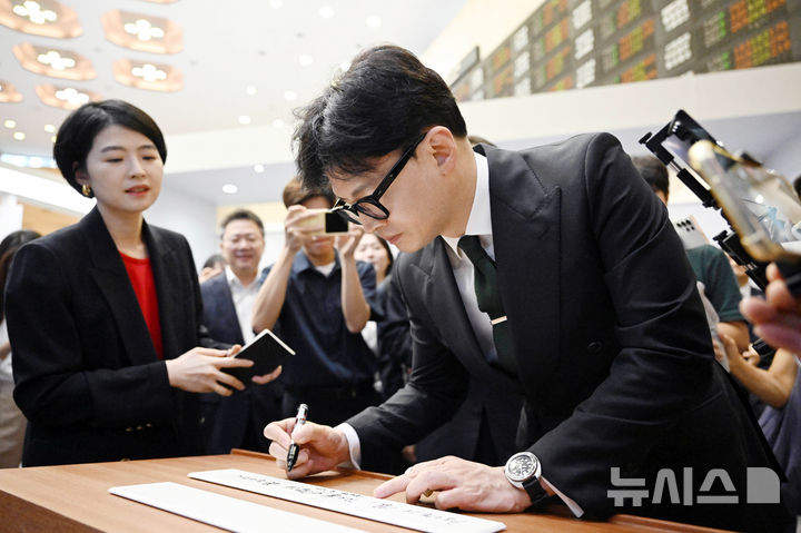 [서울=뉴시스] 최동준 기자 = 한동훈 국민의힘 대표가 27일 서울 여의도 한국거래소를 방문해 '국내 자본시장과 개인 투자자 보호를 위한 금융투자소득세 폐지 자본시장 관계자와의 간담회'에 앞서 방명록 작성을 하고 있다. (공동취재) 2024.08.26. photocdj@newsis.com