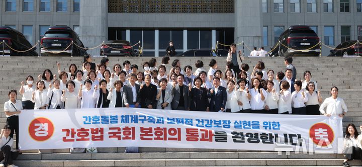 [서울=뉴시스] 조성봉 기자 = 지난달 28일 오후 서울 여의도 국회에서 열린 제417회국회(임시회) 제2차 본회의에서 간호법안(대안)이 재적300인 중 재석 290인, 찬성 283인, 반대 2인, 기권 5인으로 통과된 가운데 대한간호협회 소속 간호사들과 박주민 보건복지위원장을 비롯한 의원들이 본청 계단에서 기념촬영을 하고 있다. 2024.08.28. suncho21@newsis.com