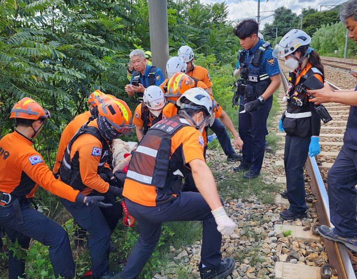 [영동=뉴시스] 안성수 기자 = 29일 29일 오전 11시29분께 충북 영동군 영동읍 오탄리 철로에서 20대 남성 A씨가 달리는 기차에 치여 두 다리가 골절돼 병원으로 이송되고 있다. (사진=영동소방서 제공) 2024.8.29. photo@newsis.com *재판매 및 DB 금지