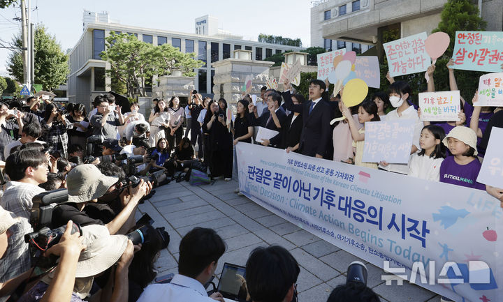 [서울=뉴시스] 최동준 기자 = 지난 29일 서울 종로구 헌법재판소 앞에서 열린 청소년기후소송, 시민기후소송 등 시민단체의 기후 헌법소원 최종 선고 공동 기자회견에서 판결은 끝이 아닌 기후 대응의 시작이라는 구호를 외치고 있다.이날 헌재는 헌법소원 4건에서 재판관 전원일치 의견으로 탄소중립기본법 8조 1항에 헌법불합치 결정을 내렸다. 2024.08.29. photocdj@newsis.com