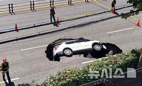 [서울=뉴시스] 29일 서울 서대문구 성산로에 발생한 땅꺼짐 사고현장에 차량이 빠져 있다. (사진=독자 제공) 2024.08.29. photo@newsis.com