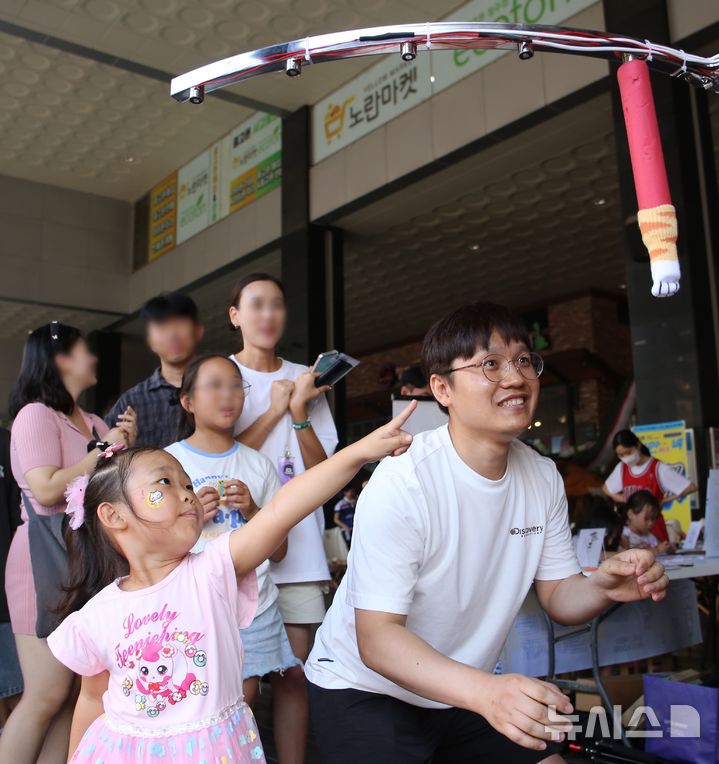 [청주=뉴시스] 서주영 기자 = 청주원도심골목길축제 '성안이즈백' 행사가 31일 오후 청주시 상당구 성안길 일대에서 열렸다. 시민들이 행사 게임코너에서 떨어지는 스틱을 잡는 게임인 '드랍스틱'을 즐기고 있다. 2024.08.31. juyeong@newsis.com