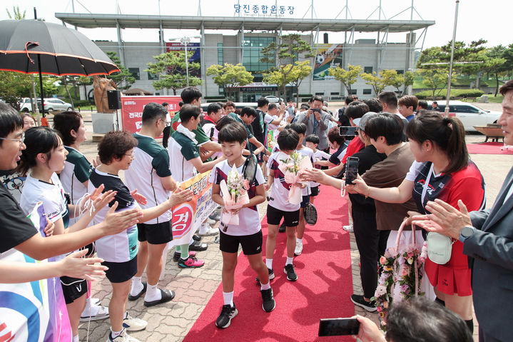 [당진=뉴시스] 지난달 31일 당진시가 전국대회 13연패를 달성한 당진초 배드민턴팀을 위해 카퍼레이드를 추진한 가운데 당진종합운동장 실내체육관에 도착한 학생들이 꽃다발을 들고 레드카펫을 걸으며 시민들의 축하를 받고 있다. (사진=당진시 제공) 2024.09.02. *재판매 및 DB 금지