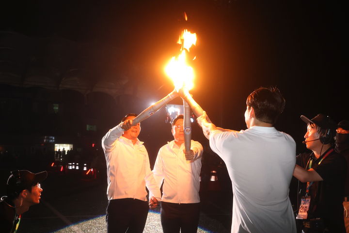 [순창=뉴시스] 김종효 기자 = 지난 6일 순창공설운동장에서 열린 제61회 전북특별자치도민체육대회 개막식, 전북특별자치도 최병관 행정부지사(뒤 오른쪽)와 최영일 순창군수(뒤 왼쪽)가 성화대 점화자인 역도 국가대표 유동준 선수에게 성화를 전달하고 있다. (사진= 순창군 제공) 2024.09.07. photo@newsis.com *재판매 및 DB 금지