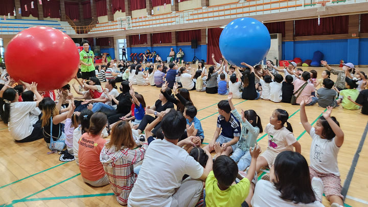 [서산=뉴시스] 지난 7일 서산중앙고등학교 체육관에서 열린 2024년 드림스타트 가족 운동회에 참가한 가족들이 큰 공 굴리기를 하고 있다. (사진=서산시 제공) 2024.09.08. *재판매 및 DB 금지