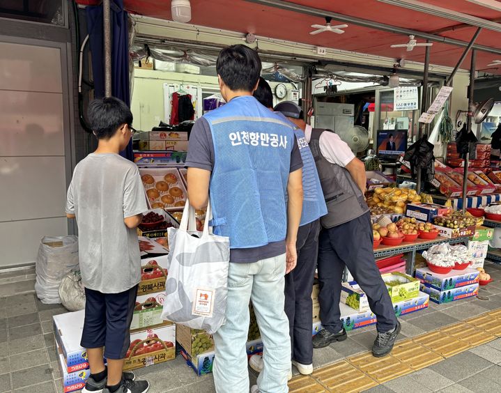 [인천=뉴시스] 저소득 가정 아동과 함께 전통시장에서 장을 보고 있다. (사진=인천항만공사 제공) *재판매 및 DB 금지