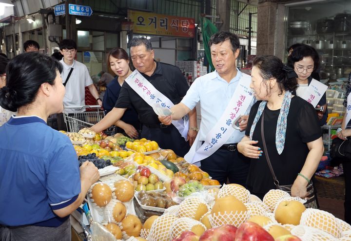 12일 추석맞이 전통시장 장보기 행사에 나선 이학수 정읍시장(오른쪽 두번째)이 샘고을시장에서 온누리상품권으로 과일을 구매하고 있다. *재판매 및 DB 금지