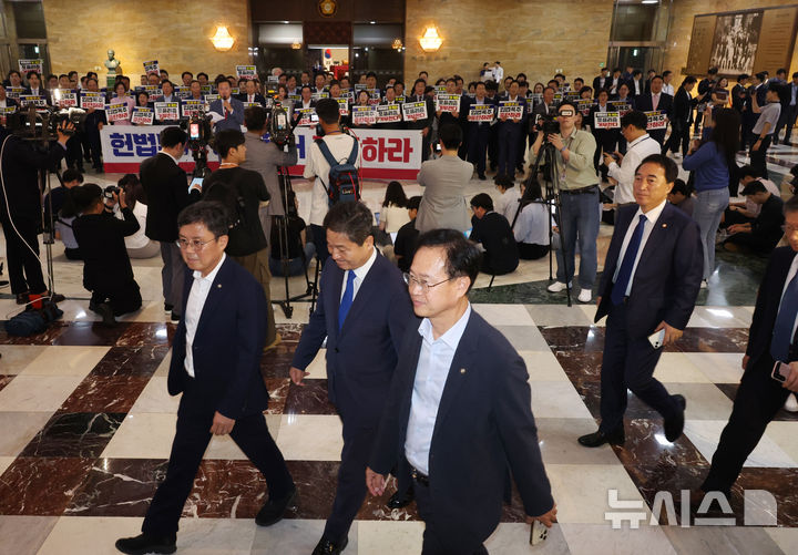 [서울=뉴시스] 고승민 기자 = 더불어민주당 의원들이 19일 서울 여의도 국회에서 열린 제418회 국회(정기회) 제8차 본회의에 참석하고 있다. 이들 뒤로 국민의힘 의원들이 입법 폭주 및 포퓰리즘 규탄 등의 피켓을 들고 구호를 외치고 있다. 2024.09.12. kkssmm99@newsis.com