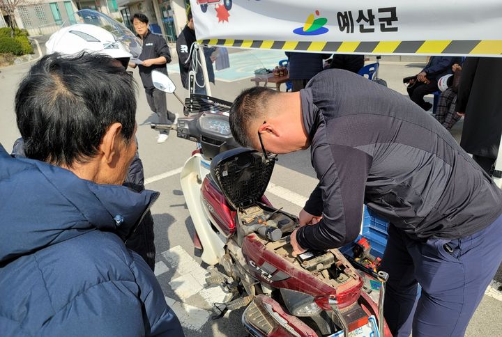 [서울=뉴시스] 한국교통안전공단과 충남 예산군이 고령운전자의 이륜차에 사고자동신고 장치를 설치하는 모습. 2024.09.20. (사진=교통안전공단 제공) photo@newsis.com *재판매 및 DB 금지