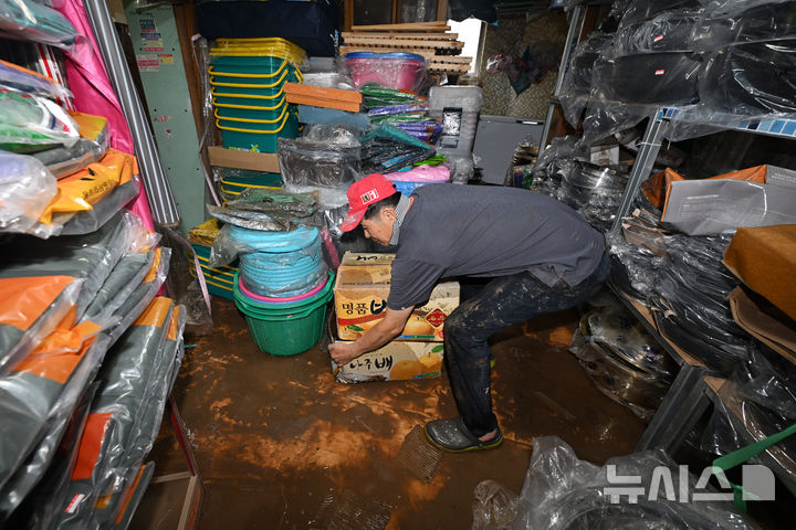 [진도=뉴시스] 이영주 기자 = 22일 오후 전남 진도군 조금시장에서 기물점을 운영하는 김종배(70)씨가 침수 피해를 입은 가게를 둘러보며 멀쩡한 물건을 건지고 있다. 진도에는 전날 오후 시간당 최대 112.2㎜ 폭우가 쏟아져 조금시장 일대와 곳곳이 침수됐다. 2024.09.22. leeyj2578@newsis.com