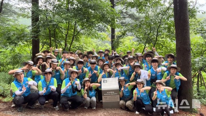 [서울=뉴시스]포스코 비욘드봉사단이 '비욘드 숲' 조성 봉사활동을 마치고 단체 사진을 찍은 모습. (사진 = 포스코 제공)