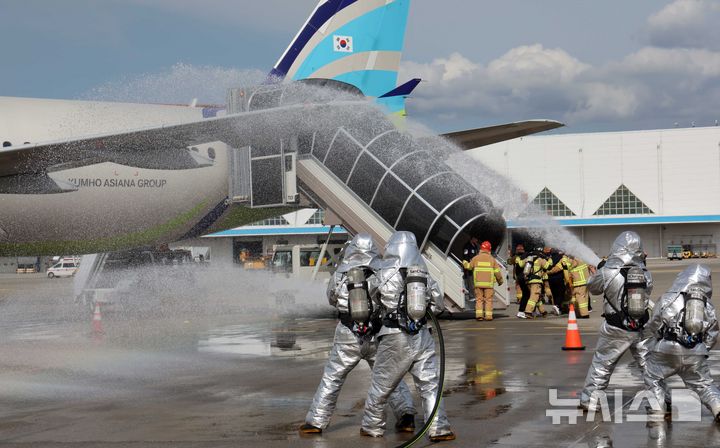 [부산=뉴시스] 하경민 기자 = '2024 재난대응 안전한국훈련 김해국제공항 항공기 사고수습 종합훈련'이 열린 26일 부산 강서구 김해국제공항에서 소방대원들이 항공기끼리 충돌사고를 가정한 화재를 진압하면서 부상 승객을 구조하고 있다.  이번 훈련에는 한국공항공사, 군, 경찰, 소방 등 31개 기관에서 250여 명이 참여했다. 2024.09.26. yulnetphoto@newsis.com